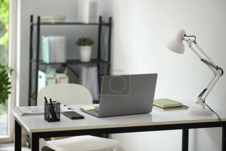 Photo for Desk of business person with laptop, lamp and documents - Royalty Free Image