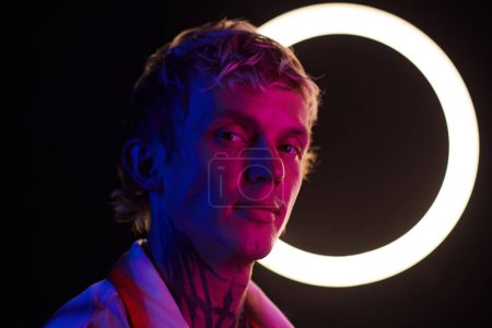 Téléchargez les photos : Portrait de jeune homme debout dans la lumière au néon, concept de vie nocturne - en image libre de droit