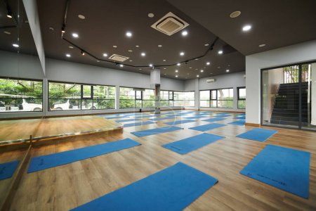 Téléchargez les photos : Studio de danse vide spacieux avec de nombreux tapis de yoga sur le plancher de bois franc - en image libre de droit