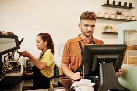 Téléchargez les photos : Propriétaire de coffeeshop travaillant au bureau de caisse quand b comme tostada faire du café - en image libre de droit