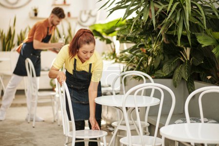 Foto de Camareros de cafetería sacando mesas y sillas para la temporada de verano - Imagen libre de derechos