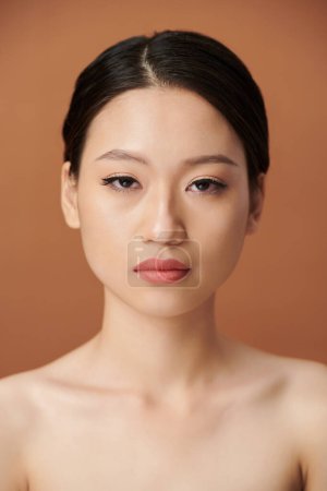 Téléchargez les photos : Sérieux jeune asiatique femme avec eye liner et lèvre teinte regarder caméra - en image libre de droit