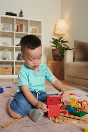 Photo for Little boy playing with toys on floor in living room - Royalty Free Image