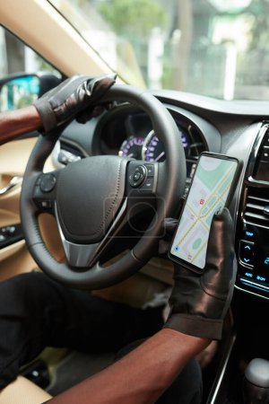 Photo for Close-up image of driver checking map application on smartphone when driving to client - Royalty Free Image