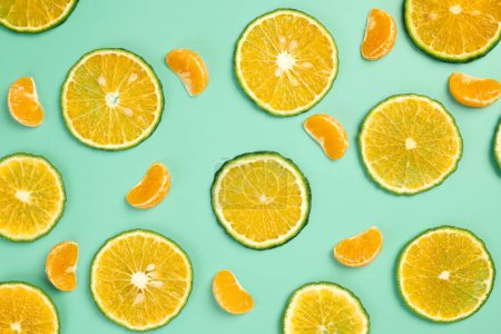 Foto de Rodajas finas y naranjas con cáscara verde y segmentos de mandarina en la mesa - Imagen libre de derechos
