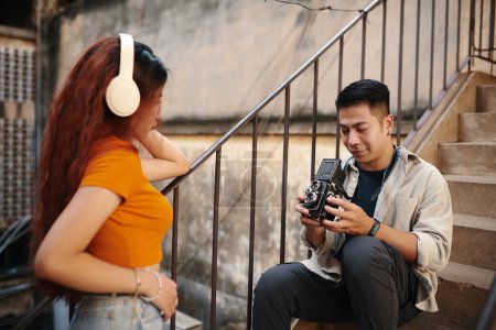 Téléchargez les photos : Jeune homme photographiant petite amie sur vieil appareil photo - en image libre de droit