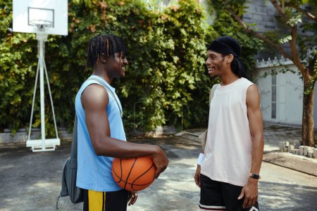 Téléchargez les photos : Meilleurs amis excités se réunissant en plein air pour jouer au basket - en image libre de droit
