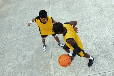 Téléchargez les photos : Homme noir en vêtements de sport jouant au streetball, vue de dessus - en image libre de droit
