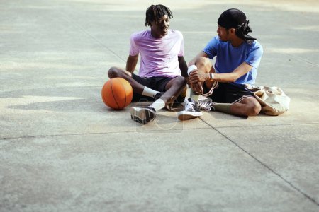Photo for Positive Black streetball players hanging out together playing and discussing news - Royalty Free Image