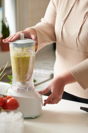 Photo for Woman blending ingrediens for healthy fruit smoothie - Royalty Free Image