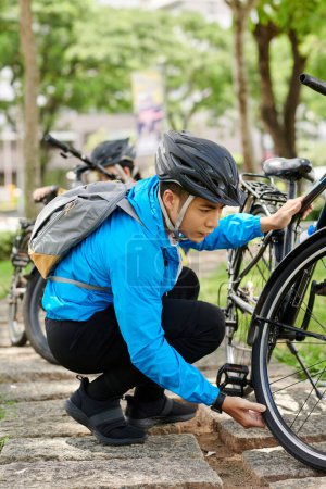 Photo for Man checking if bicycle tires are pumped enough before ride - Royalty Free Image