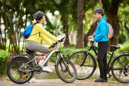 Photo for Happy friends meeting in park to ride bicycles in park together - Royalty Free Image