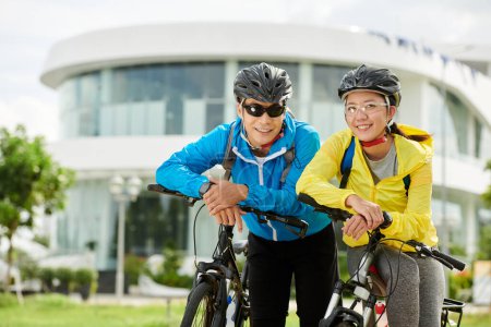 Téléchargez les photos : Portrait de heureux actif jeune couple asiatique avec des vélos souriant à la caméra - en image libre de droit