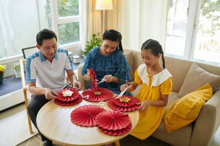 Téléchargez les photos : Artisanat de famille vietnamienne à la maison préparant des décorations pour la célébration du Nouvel An lunaire - en image libre de droit