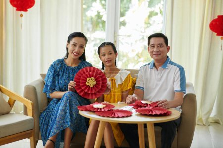 Photo for Happy Vietnamese family showing paper decoration they made for Lunar New Year - Royalty Free Image