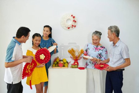 Foto de Familia preparando mesa con frutas y decoraciones para la celebración del Tet - Imagen libre de derechos