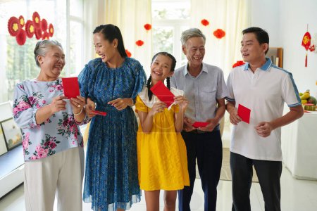 Téléchargez les photos : Joyeuse famille vietnamienne avec de l'argent chanceux enveloppes rouges - en image libre de droit