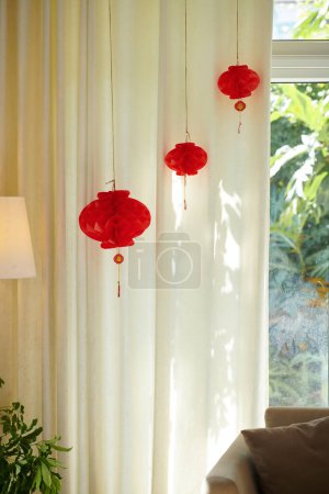 Téléchargez les photos : Lanternes en papier rouge suspendues dans la chambre décorée pour la fête du Têt - en image libre de droit