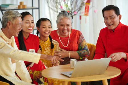 Foto de Gran familia viendo películas de comedia y tomando té cuando pasa el Año Nuevo Lunar en casa - Imagen libre de derechos