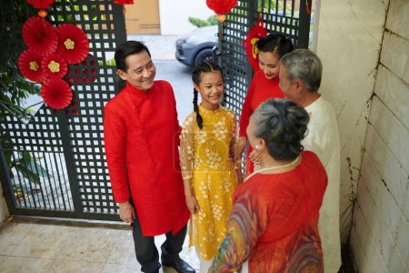 Téléchargez les photos : Couple avec adolescente rendant visite aux parents aînés pour le Nouvel An chinois - en image libre de droit