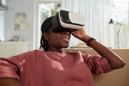 Photo for Smiling girl spending time at home playing vr game - Royalty Free Image