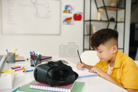 Photo for Creative boy drawing in textbook in class - Royalty Free Image