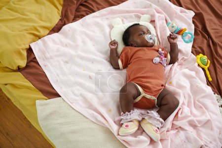 Foto de Bebé recién nacido negro durmiendo en la cama y chupando chupete, vista superior - Imagen libre de derechos