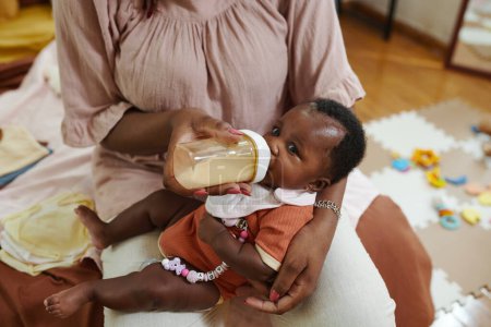 Téléchargez les photos : Mère nourrissant bébé fille avec formule - en image libre de droit