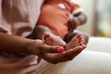 Foto de Los pequeños pies del bebé recién nacido en la mano de la madre - Imagen libre de derechos