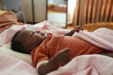 Foto de Lindo bebé en algodón bebé crecer acostado en la cama en suave manta rosa - Imagen libre de derechos
