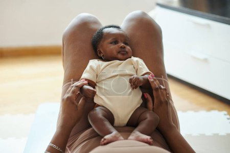 Téléchargez les photos : Femme noire jouant avec bébé après avoir fait des exercices sur un tapis de yoga - en image libre de droit