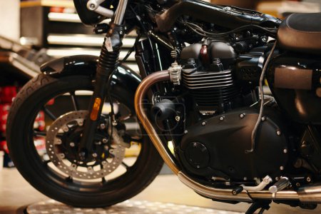 Téléchargez les photos : Image recadrée de la moto dans le garage moderne du réparateur - en image libre de droit