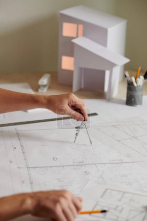 Photo for Civil engineer using compass when working on building blueprint - Royalty Free Image