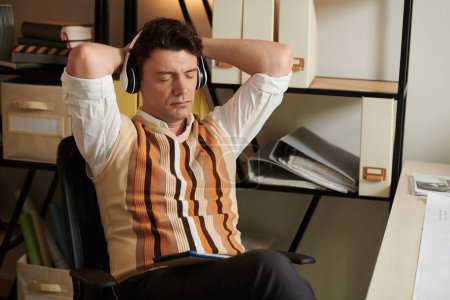 Téléchargez les photos : Architecte écouter de la musique avec les yeux fermés pour se reposer après fiinishig grand projet - en image libre de droit