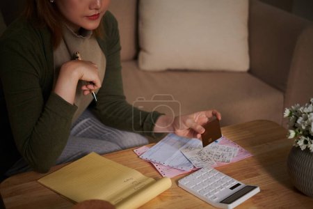 Photo for Cropped image of young woman checking her credit card loan - Royalty Free Image