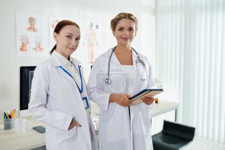 Téléchargez les photos : Équipe de jeunes femmes médecins debout dans le cabinet médical - en image libre de droit