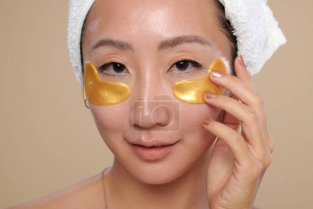 Téléchargez les photos : Visage de la jeune femme chinoise appliquant sous les patchs hydrogel oculaire - en image libre de droit