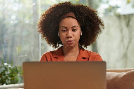 Téléchargez les photos : Portrait de femme regardant la vidéo éducative sur ordinateur portable à la maison - en image libre de droit