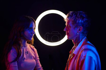 Photo for Young man and woman looking at each other in night club, love from the fist sight - Royalty Free Image
