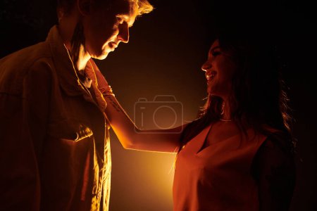 Photo for Happy young woman in love putting hand on shoulder of her boyfriend and looking in his eyes - Royalty Free Image