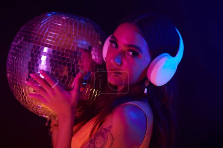Photo for Portrait of club girl in headphones holding disco ball - Royalty Free Image