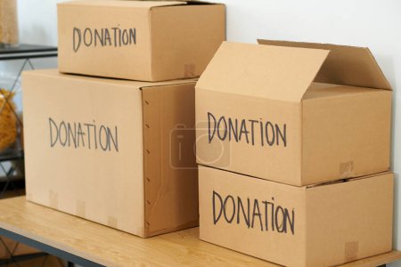 Téléchargez les photos : Boîtes en carton contenant des biens donnés au bureau d'un organisme de bienfaisance - en image libre de droit