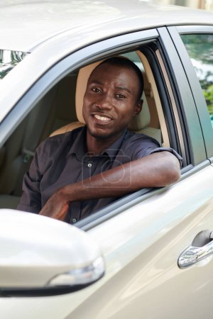 Photo for Portrait of happy Black man enjoying driving his new car - Royalty Free Image