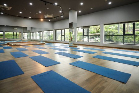 Foto de Gran sala de baile espaciosa con esteras de yoga desplegadas en el suelo - Imagen libre de derechos