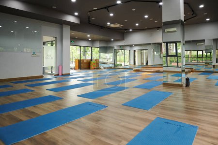 Foto de Amplia sala de baile con espejos, colchonetas de yoga y ladrillos preparados para los clientes - Imagen libre de derechos