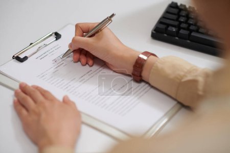 Photo for Bank manager filling mortgage loan agreement form for client - Royalty Free Image
