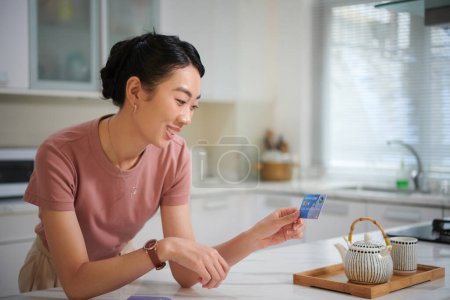 Photo for Woman putting stickers on credit card to customize and personalize it - Royalty Free Image
