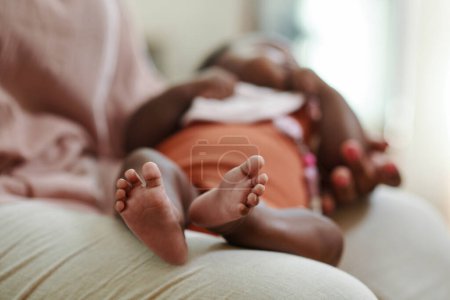 Photo for Baby girl sleeping on laps of her mother, focus on feet - Royalty Free Image