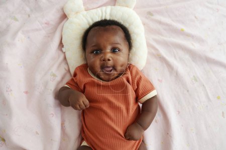 Téléchargez les photos : Portrait de fille nouveau-né noir couché sur le lit avec oreiller bébé, vue de dessus - en image libre de droit