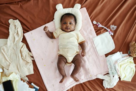 Téléchargez les photos : Petite fille couchée sur le lit avec la tête reposant sur un oreiller pour bébé, vue de dessus - en image libre de droit